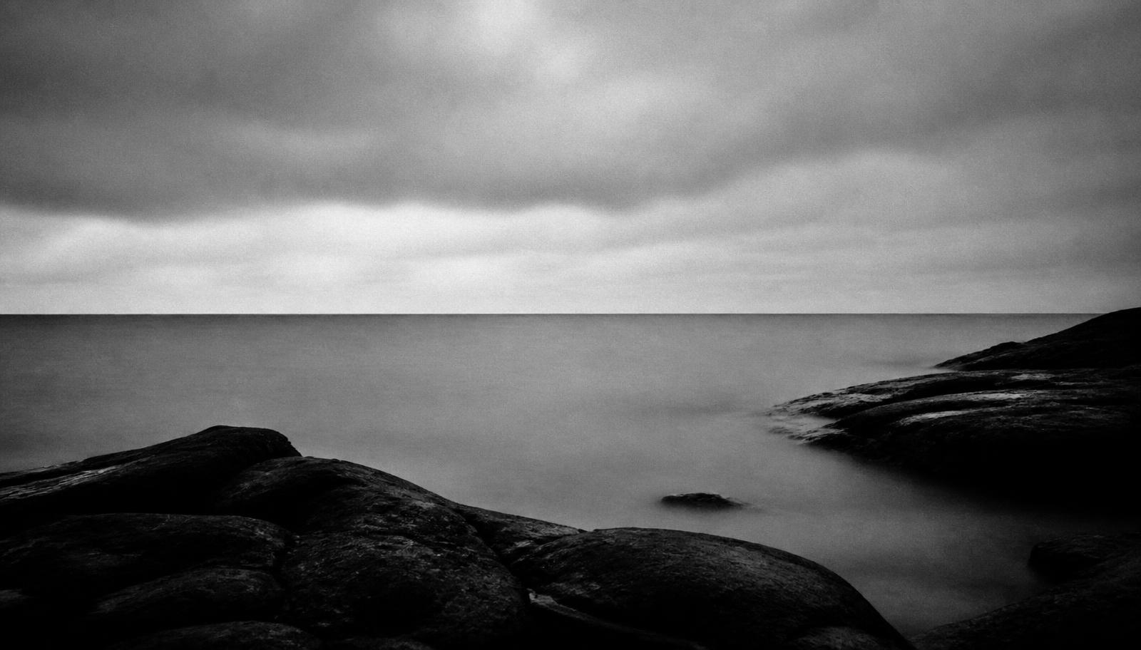 A calm sea horizon under a grey Nordic sky